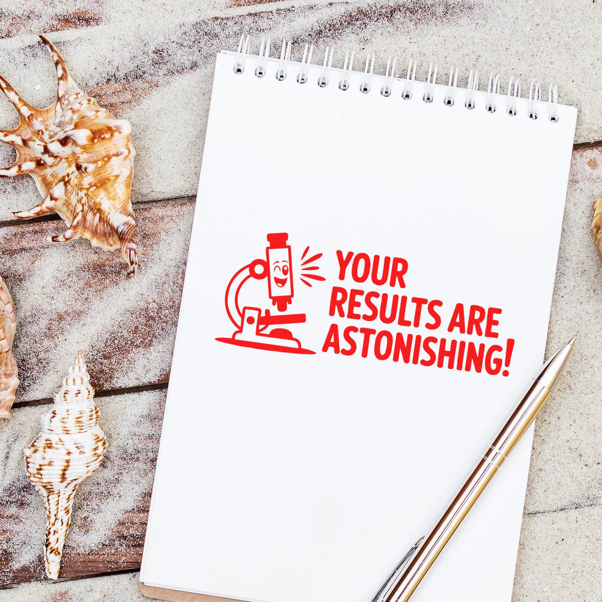 Custom rubber stamp on notebook reading Your results are astonishing! with microscope icon, seashells, and pen.