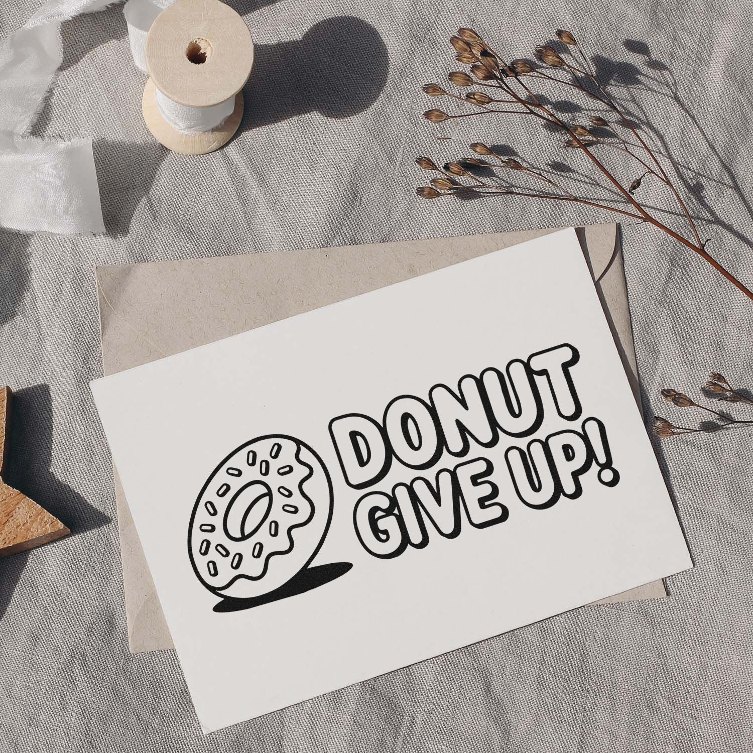 Donut Give Up rubber stamp design on a greeting card, featuring a cute motivational donut illustration for stationery and bakery crafts.