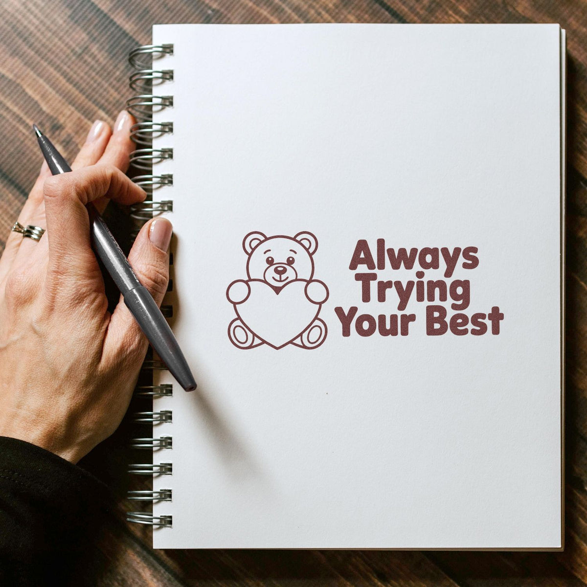 Motivational teddy bear rubber stamp with Always Trying Your Best on a blank notebook page for journaling or crafting.