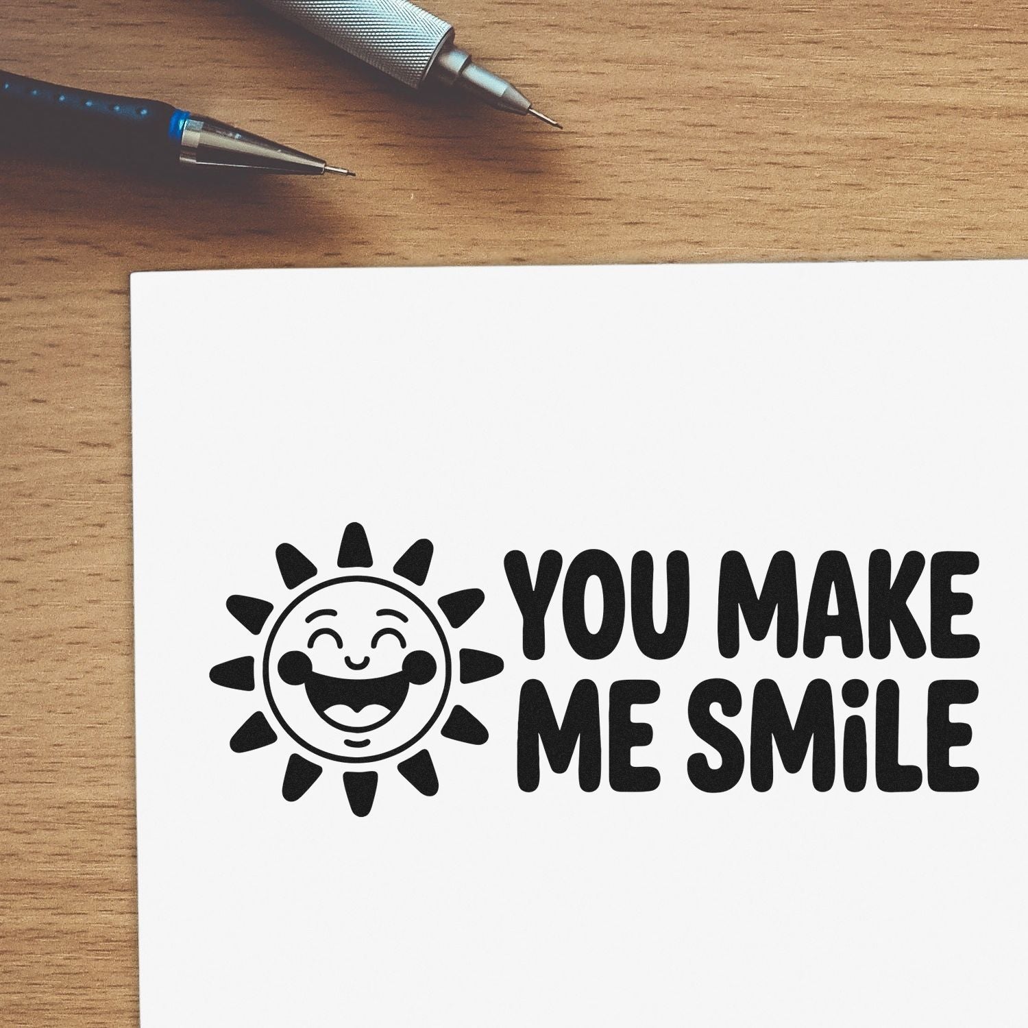 Cheerful custom rubber stamp design with smiling sun and You Make Me Smile text on white paper.