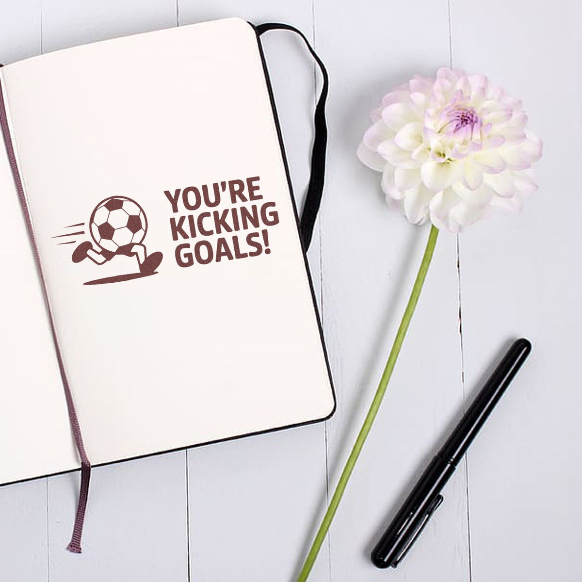 Soccer rubber stamp with Youre kicking goals! in a notebook, ideal for sports-themed cards, planners, and crafts.