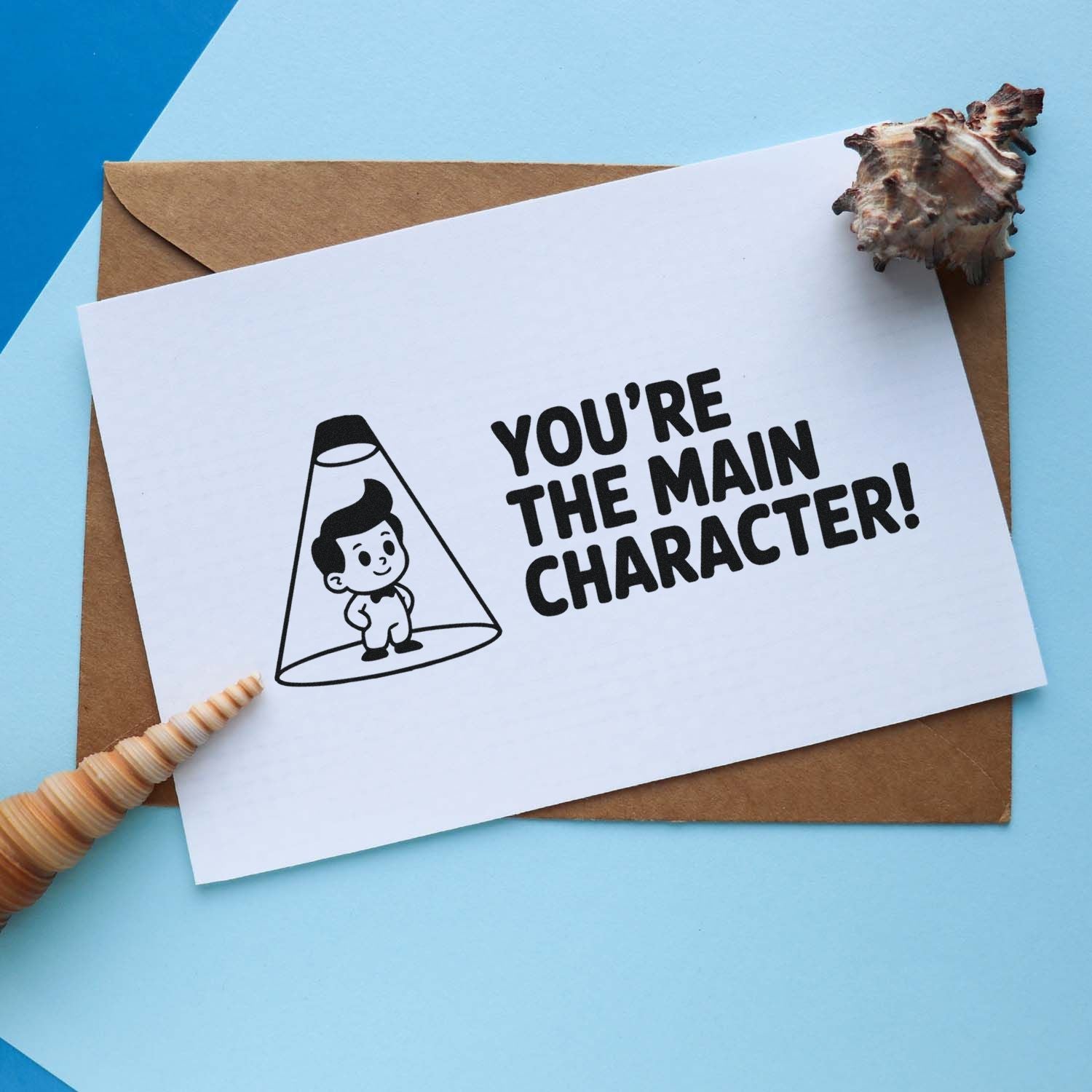 Custom rubber stamp greeting card reading Youre the Main Character! with cute spotlight character illustration.