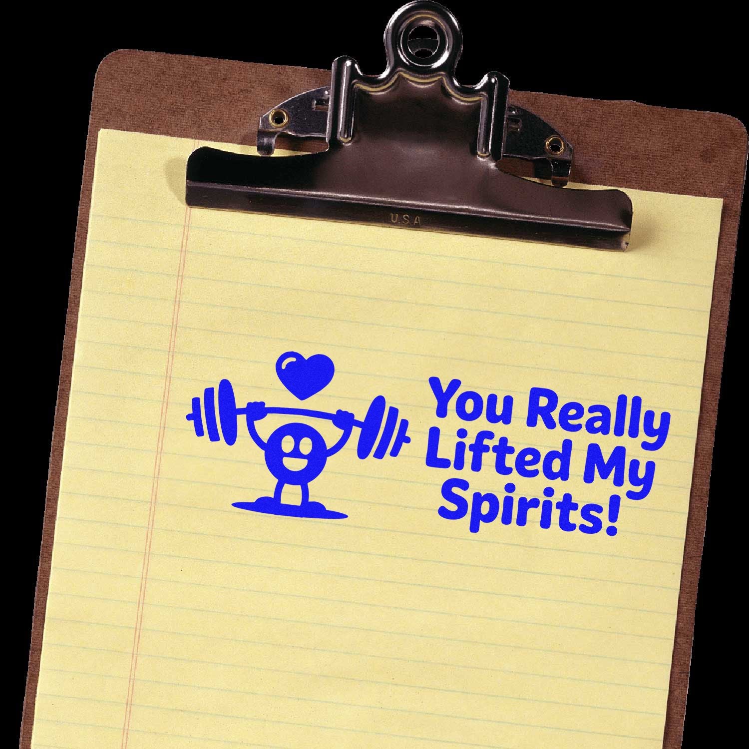 Rubber stamp on clipboard with weightlifter and heart design reading You Really Lifted My Spirits! for uplifting cards.