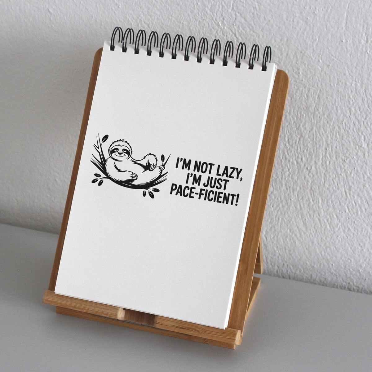 Sloth rubber stamp design with Im not lazy, Im just pace-ficient! quote on a notebook page.