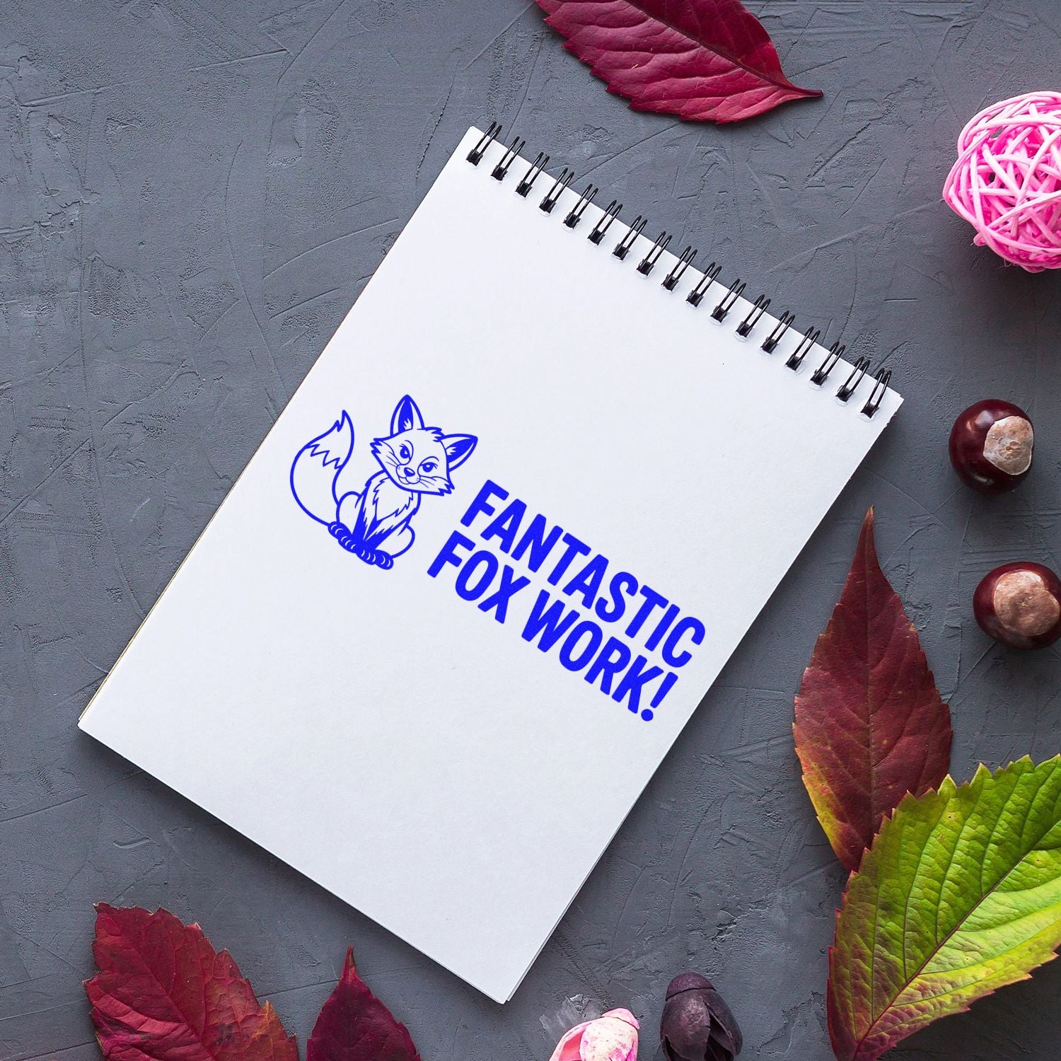 Custom rubber stamp mockup with fox logo and Fantastic Fox Work! on a notebook page.