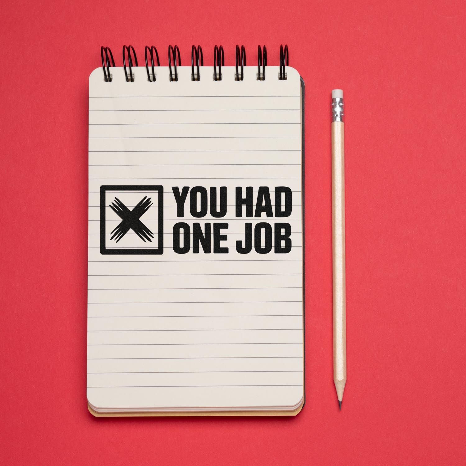 Rubber stamp imprint reading You Had One Job on a notebook, ideal for office humor and custom stamp designs.