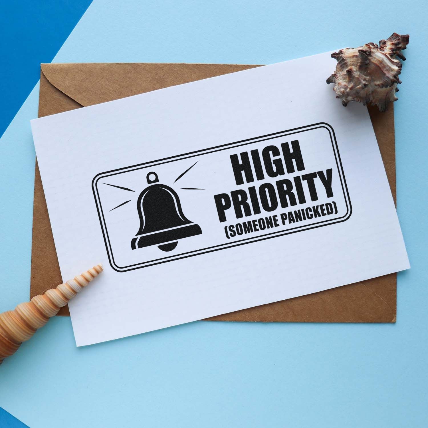 Humorous custom rubber stamp reading High Priority (Someone Panicked) on paper card over an envelope.