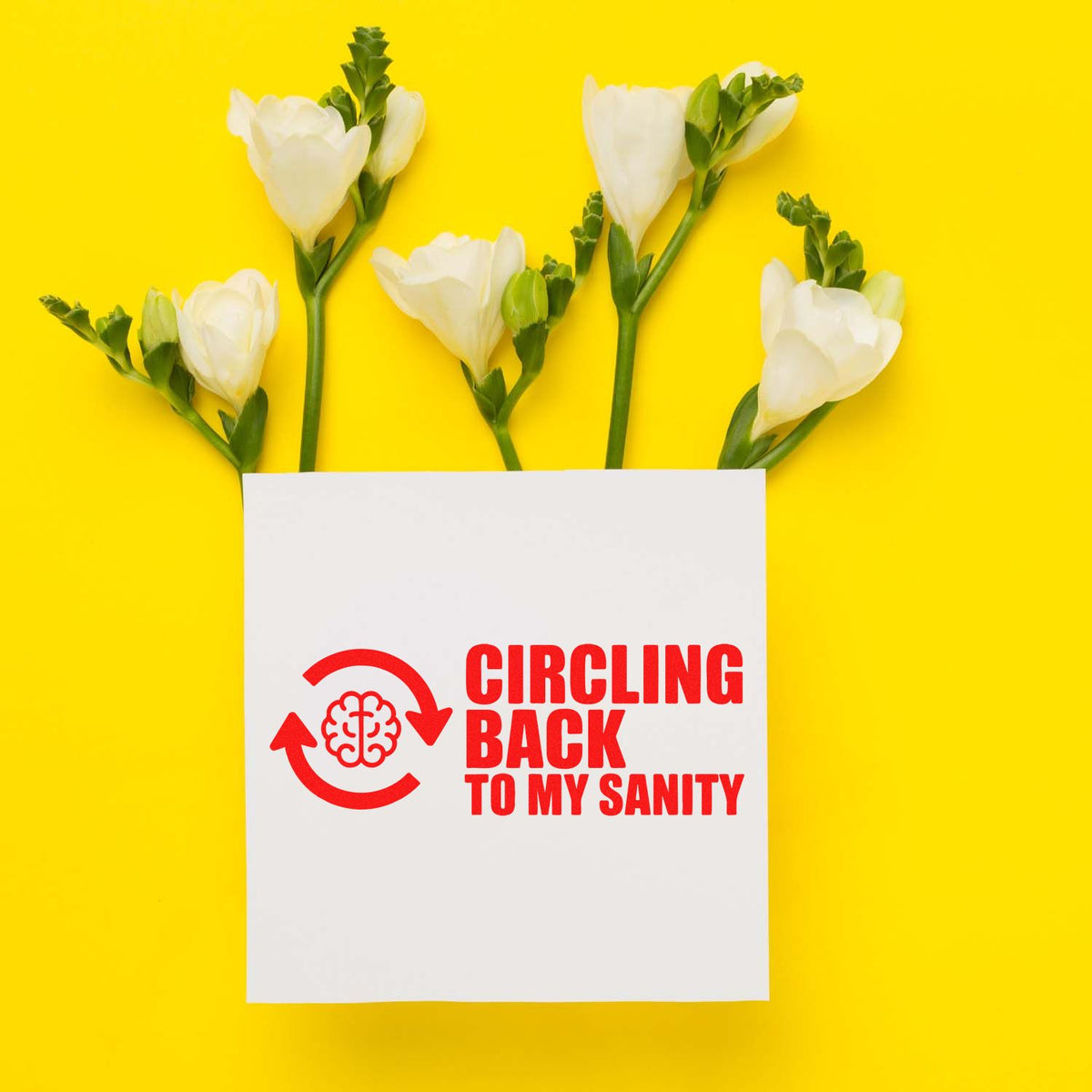 Custom rubber stamp mockup reading Circling Back to My Sanity with floral flat lay on a bright yellow background.