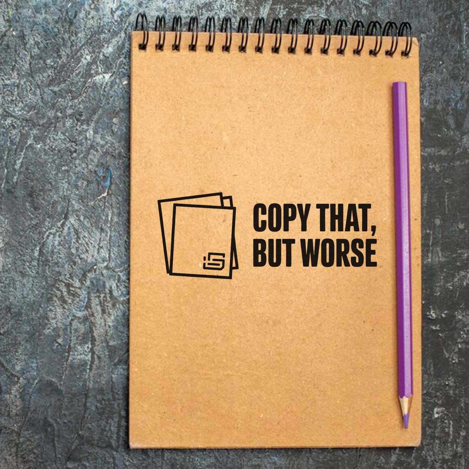 Custom rubber stamp design reading Copy That, But Worse on a notebook, perfect for funny office and stationery branding.