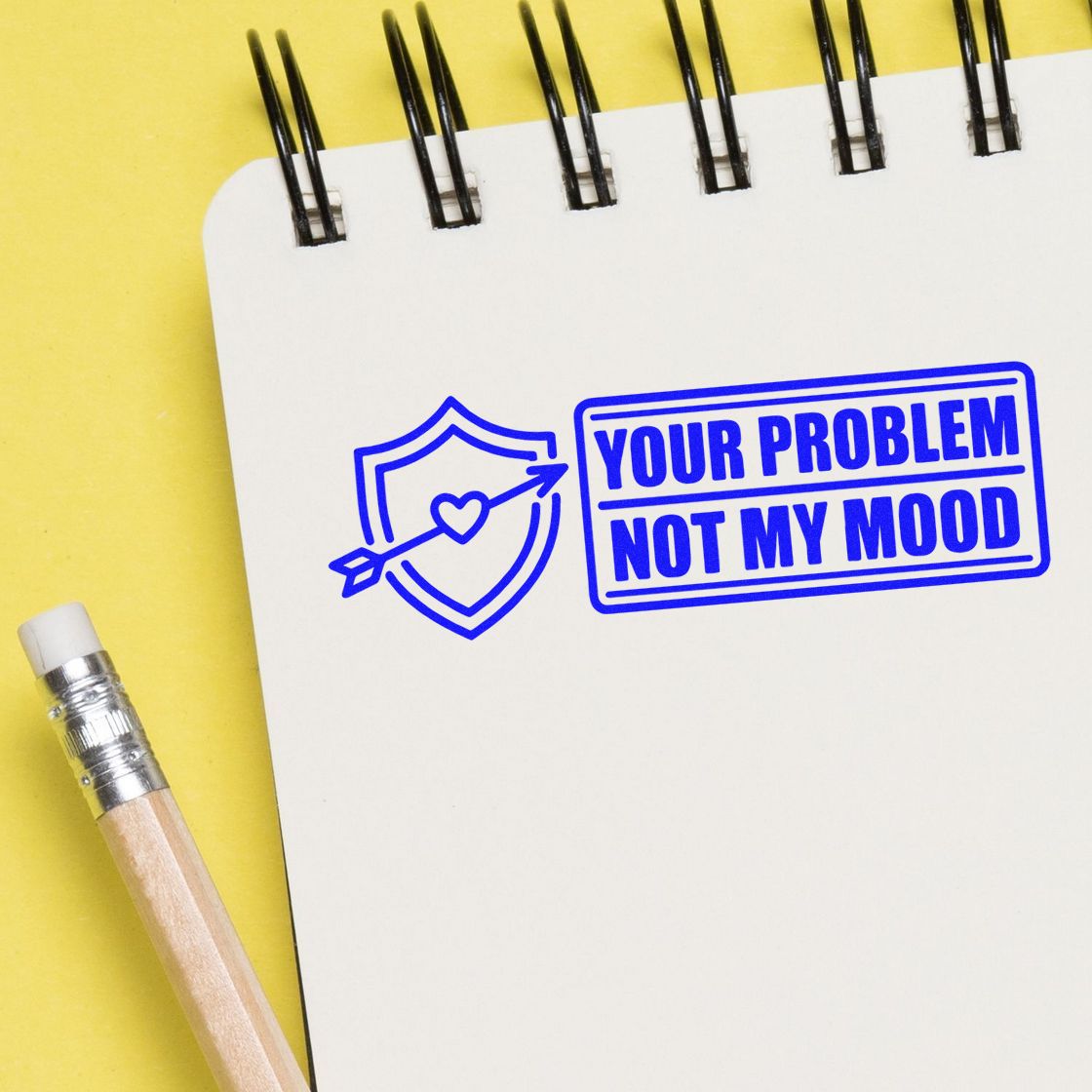 Custom rubber stamp design reading Your Problem Not My Mood with shield and arrow icon on a notebook page.