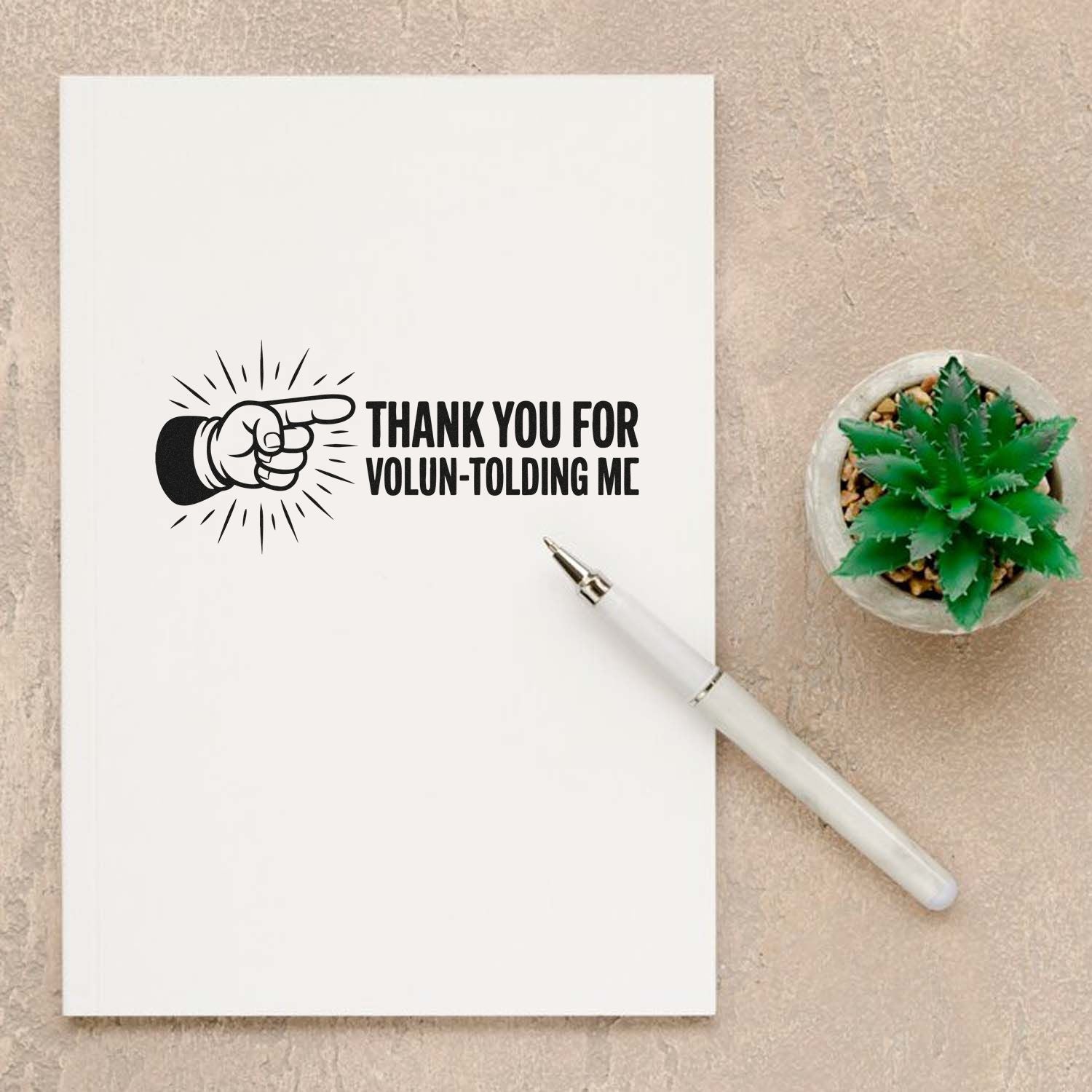Volunteer thank you rubber stamp impression on paper with pointing hand design, perfect for appreciation cards and craft projects.