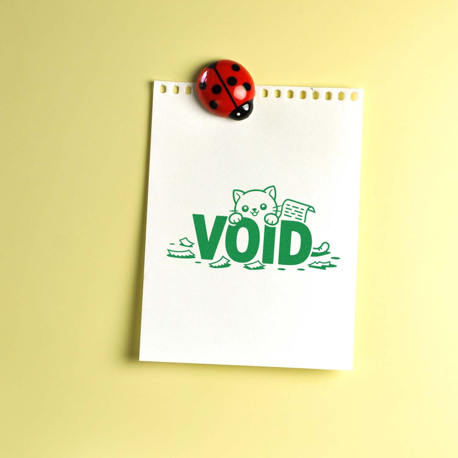 VOID rubber stamp impression on notepad paper with ladybug clip, marking documents invalid.