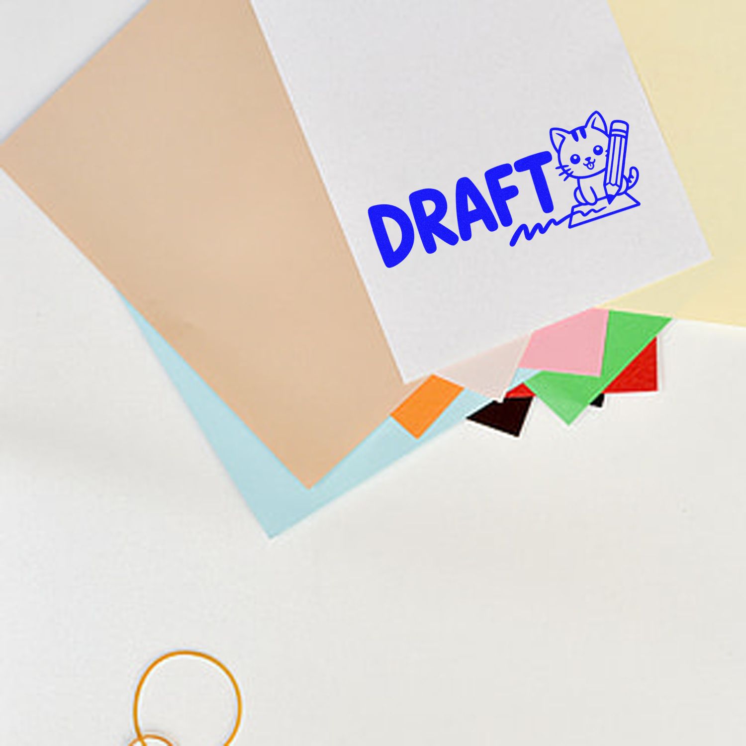 Draft rubber stamp with cat and pencil icon on paper, used to mark documents and stationery in progress.