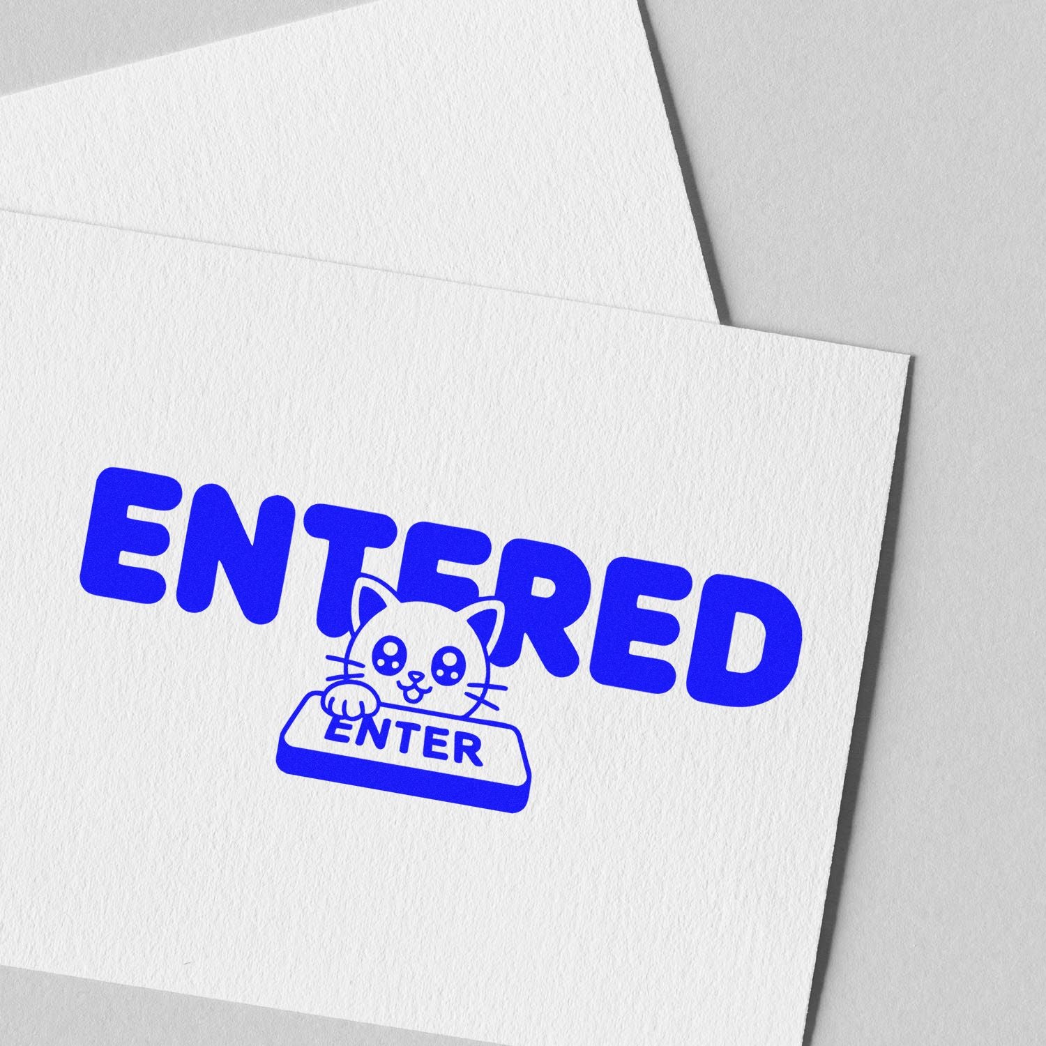 Custom blue ENTERED rubber stamp with cat icon on white envelope for office mail processing.