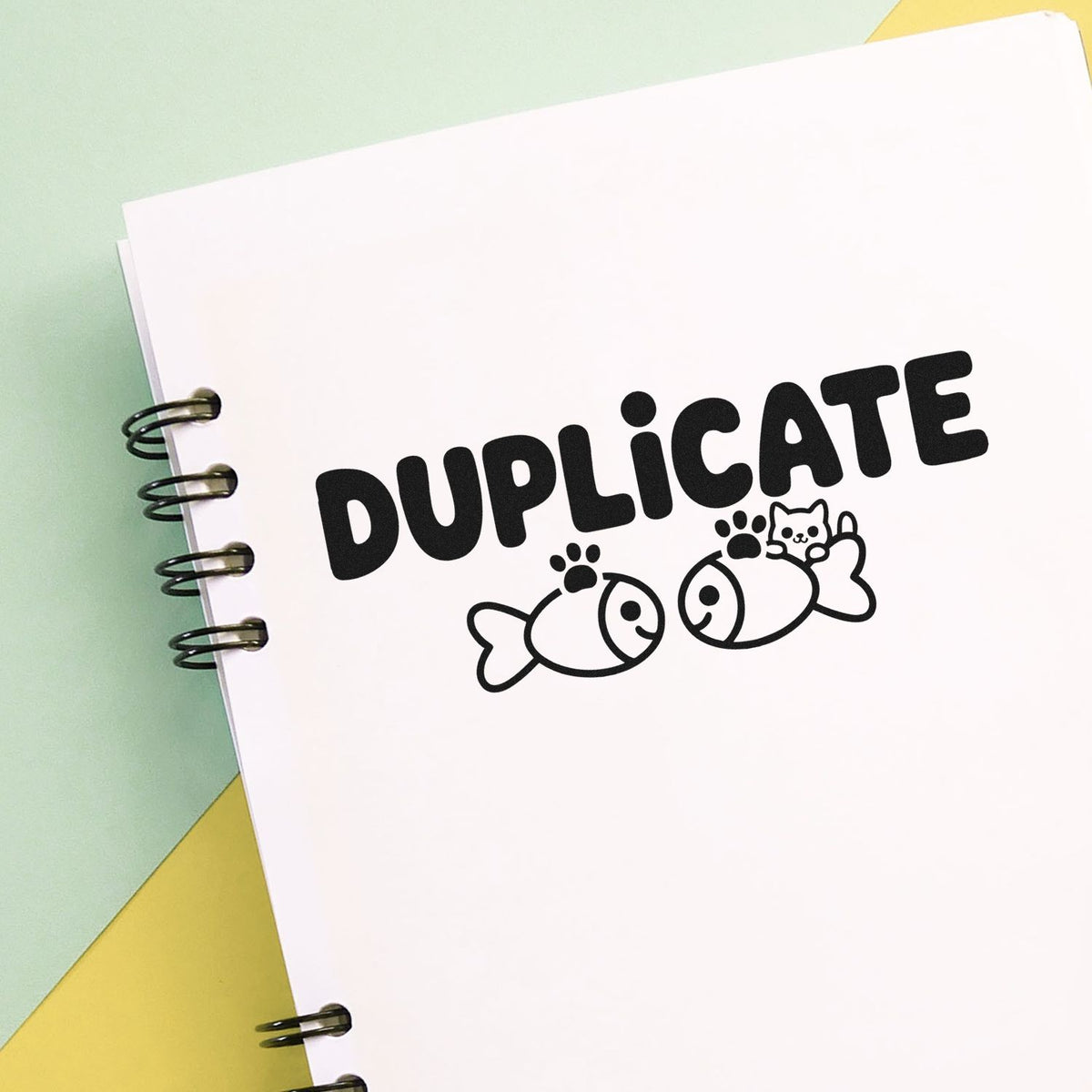 Duplicate rubber stamp design with fish and cat icon, perfect for notebook labeling, crafts, and office use.