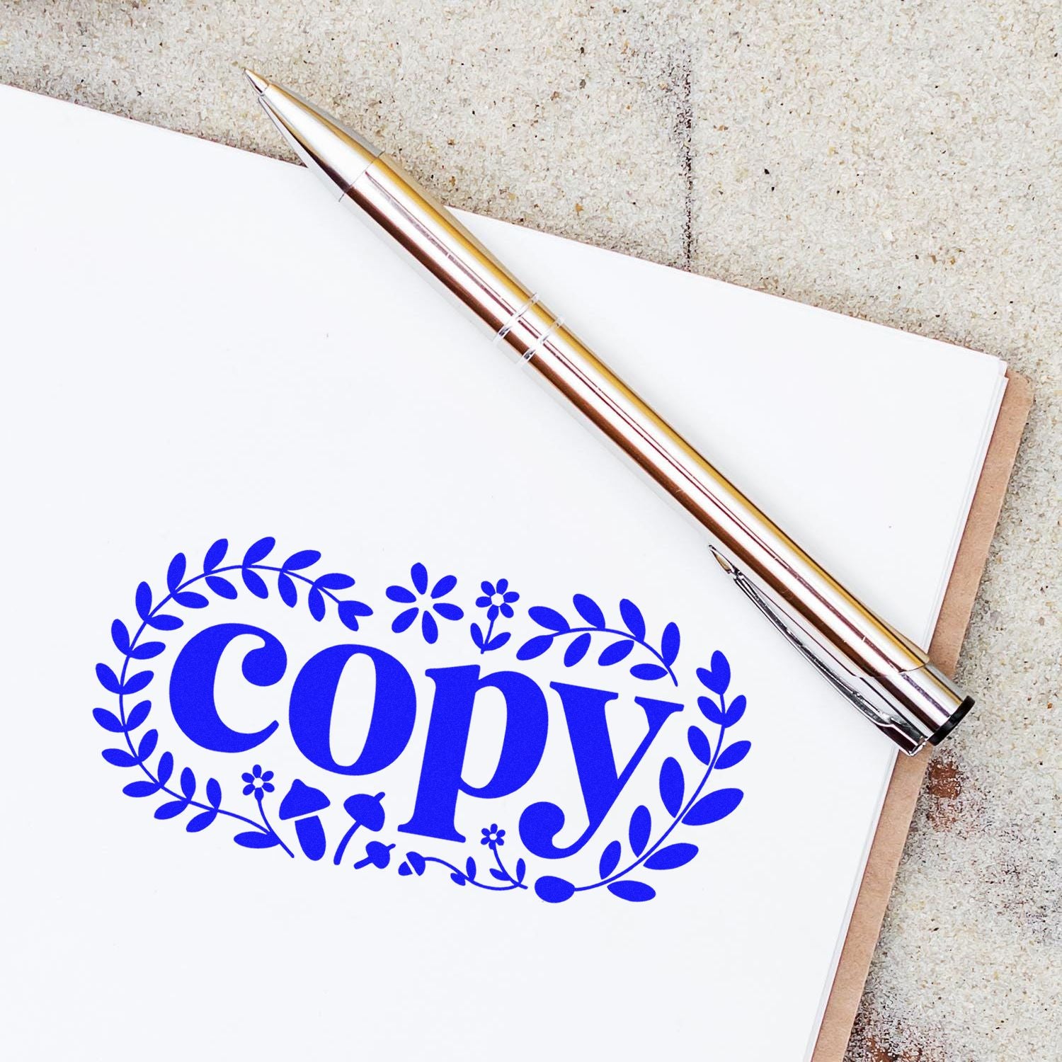 Custom floral copy rubber stamp on notebook with pen, perfect for office document marking.