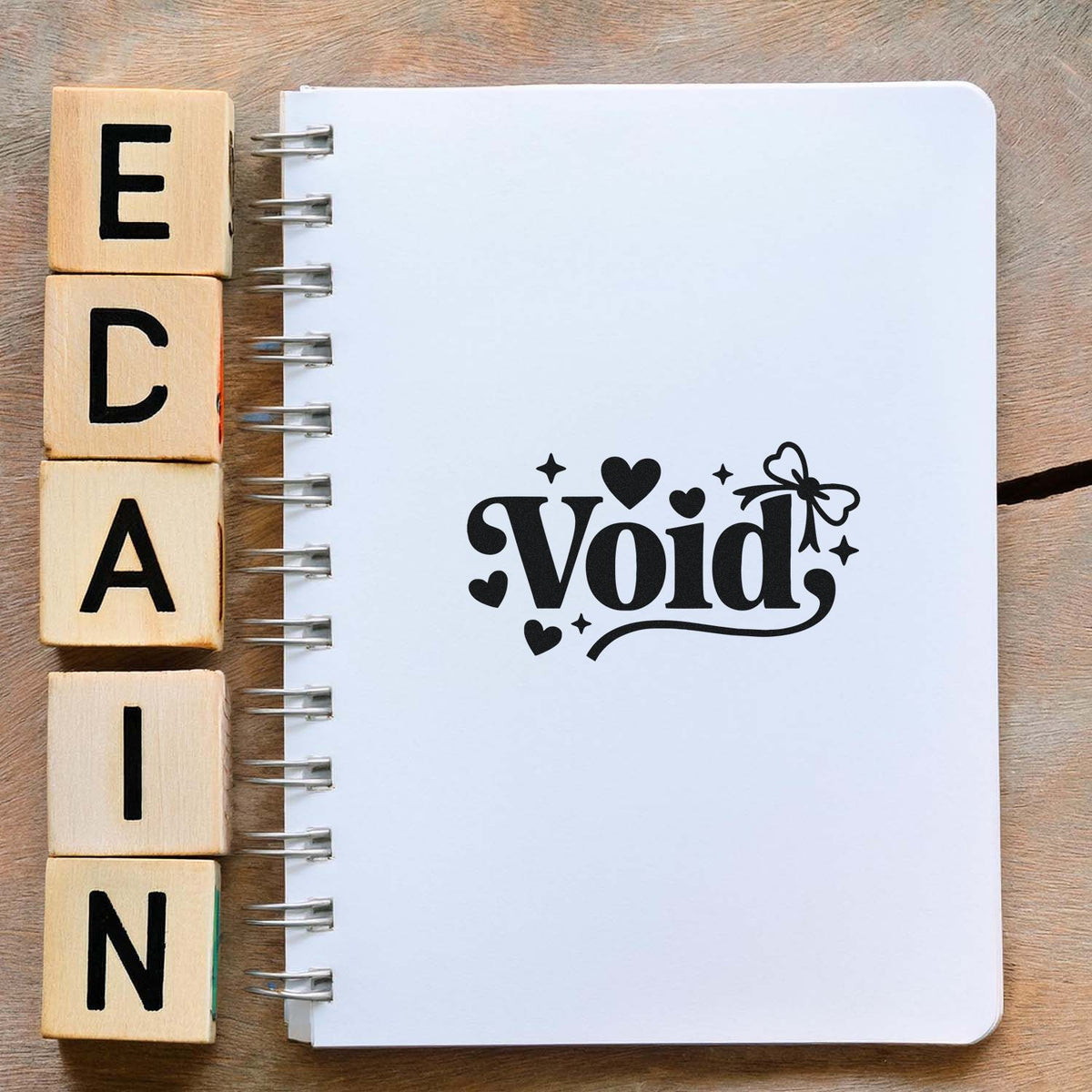 Decorative Void rubber stamp design on a notebook, with alphabet wood blocks for custom craft and stationery stamping.
