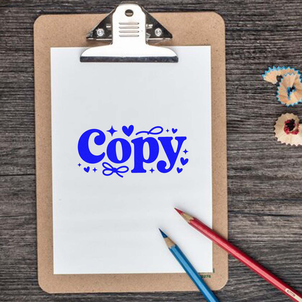 Blue Copy rubber stamp design on a clipboard with pencils, perfect for office paperwork and stationery branding.
