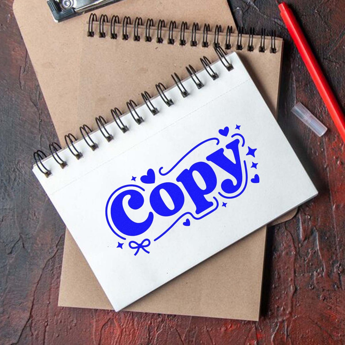 Blue COPY rubber stamp impression on spiral notebook for office paperwork, labeling, and custom branding.