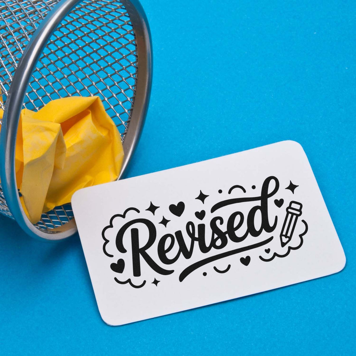 Revised rubber stamp with decorative script, hearts, and pencil icon for office document approval.