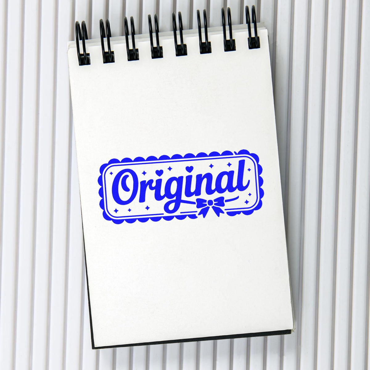 Blue Original rubber stamp impression on notebook, showcasing a custom decorative stamp design for branding.