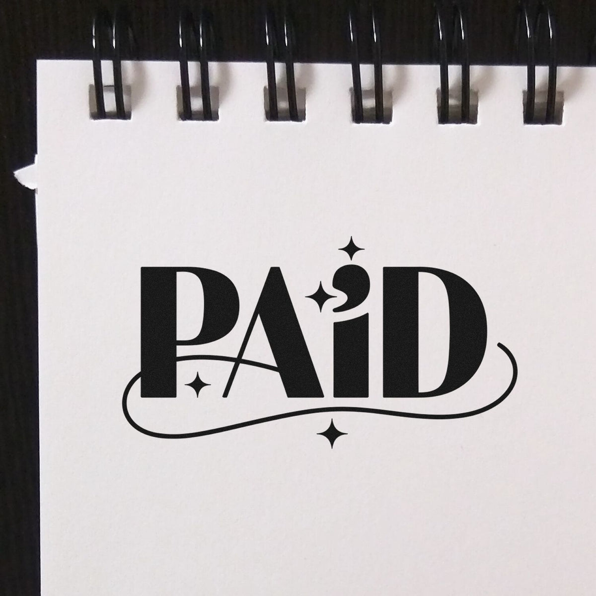 PAID rubber stamp design with decorative stars and underline for invoices, receipts, and bookkeeping.