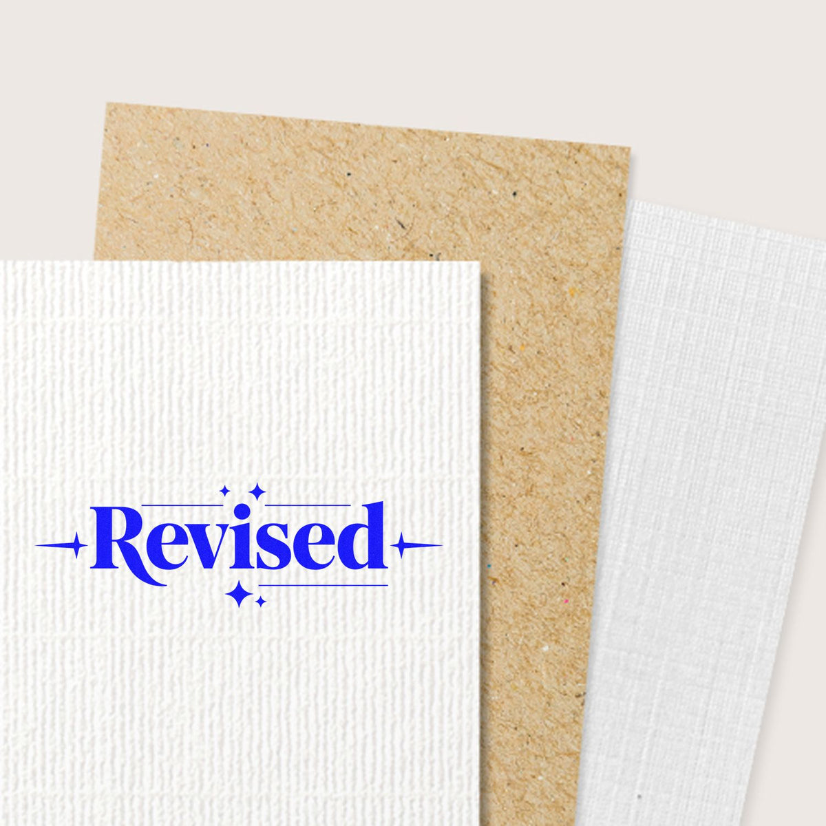 Blue Revised rubber stamp on textured paper, used for document review, editing, and office approval.