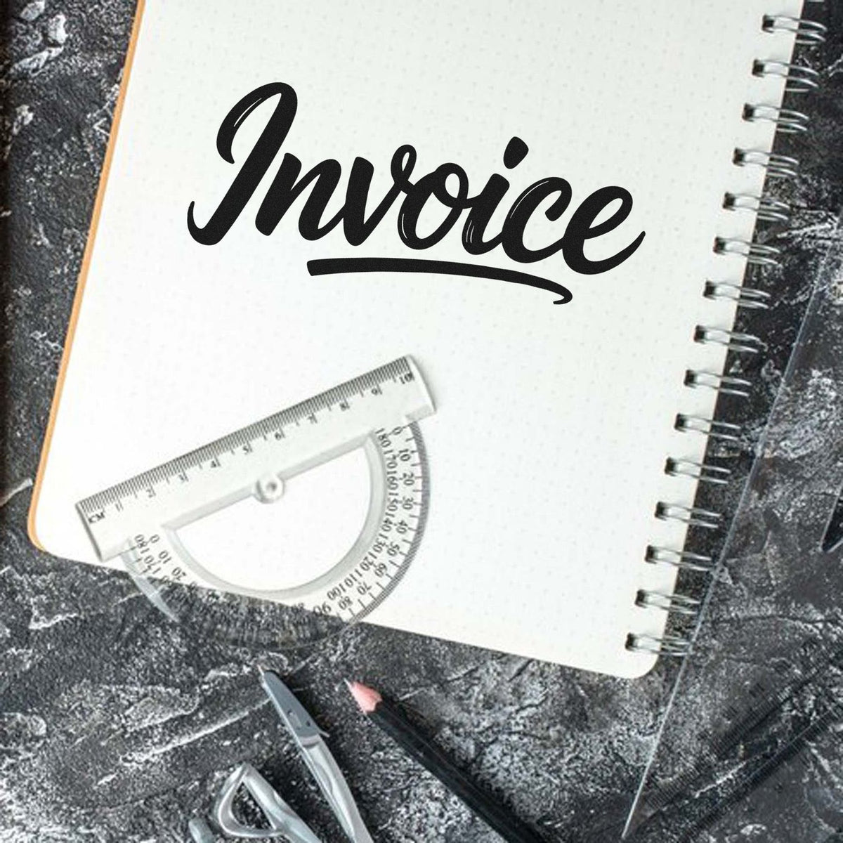 Invoice rubber stamp on notebook, ideal for business bookkeeping, billing, and office organization.