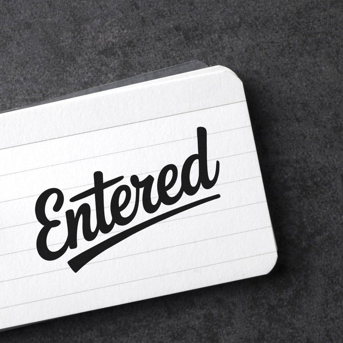 Entered rubber stamp impression on lined paper for office document processing and approval tracking.