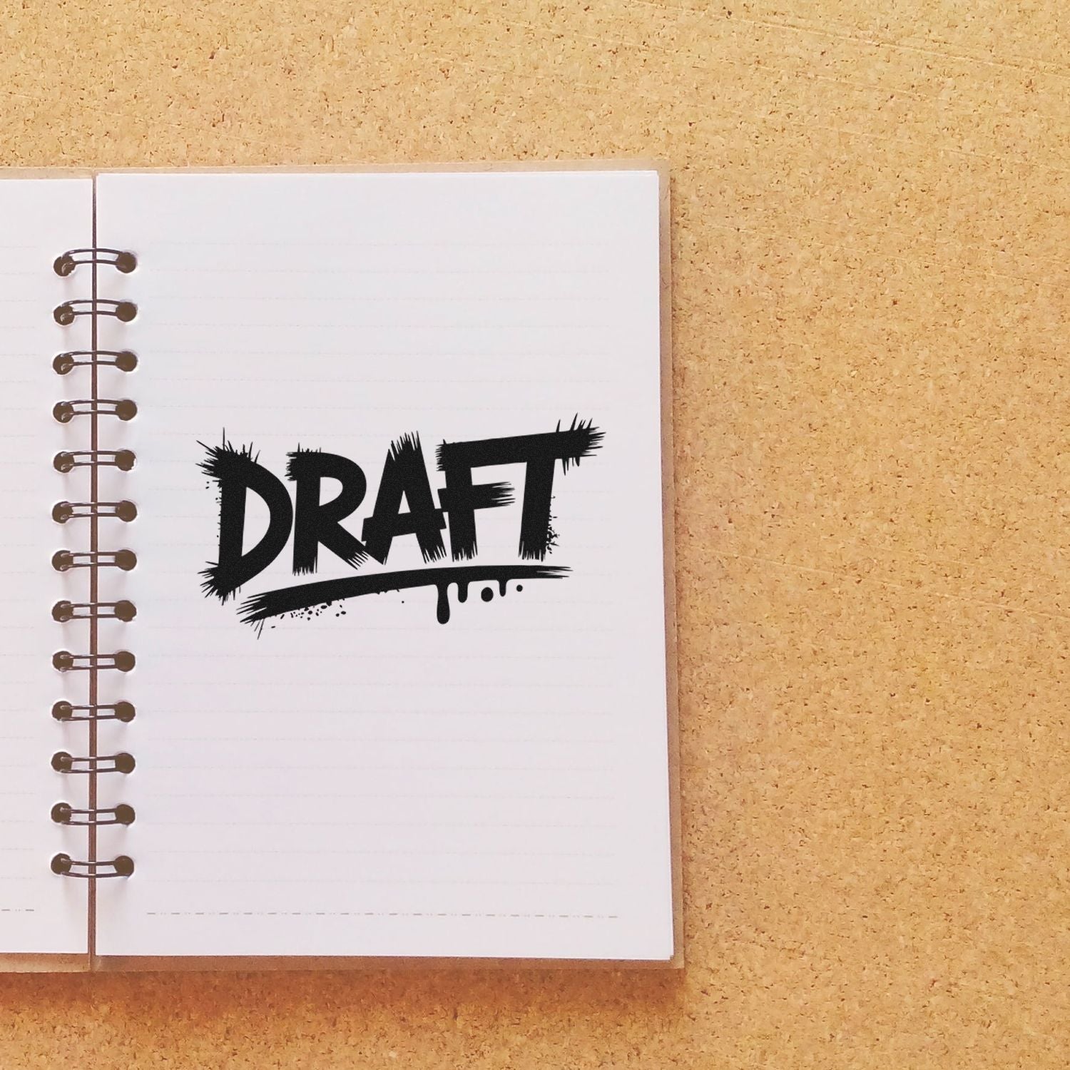 Black DRAFT rubber stamp on notebook page for marking documents, notes, or proofs as drafts.