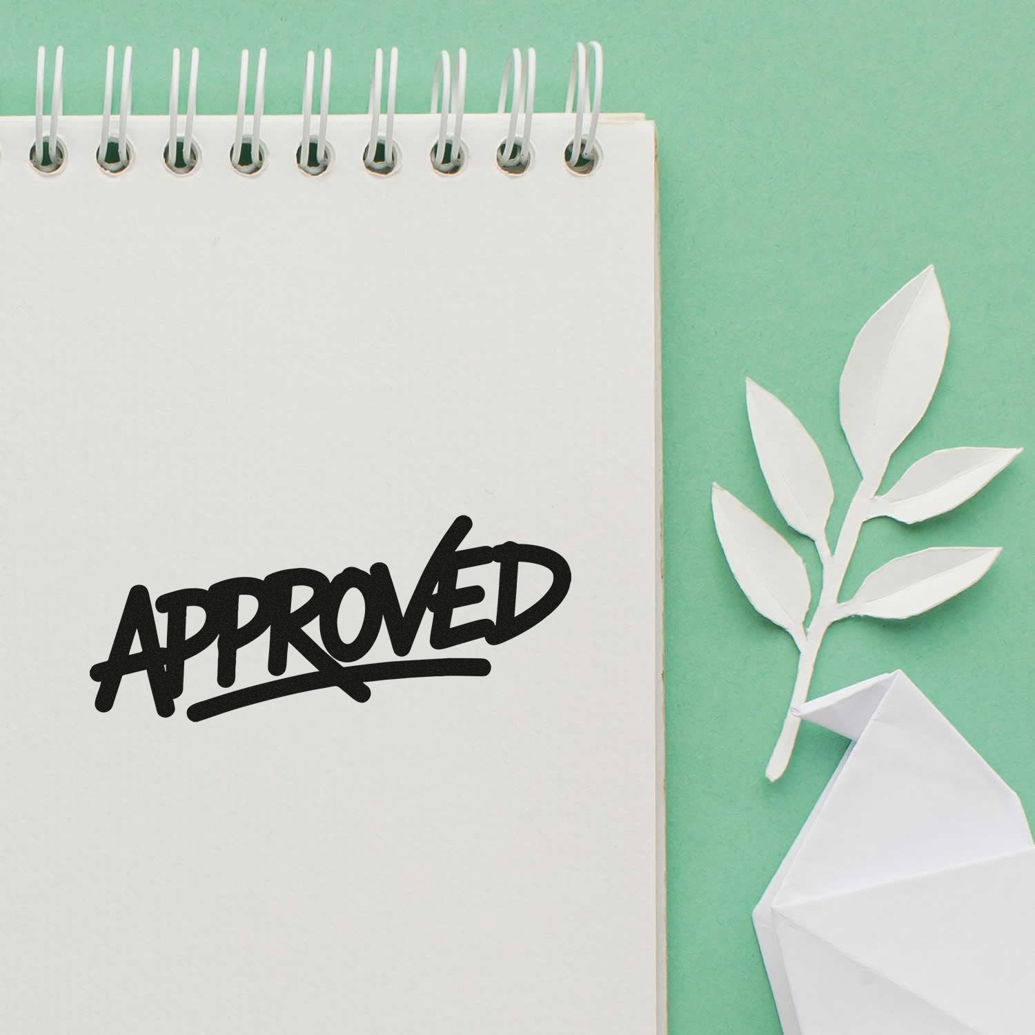 Approved rubber stamp impression on notebook page with paper craft decor, showcasing office approval stamp design.
