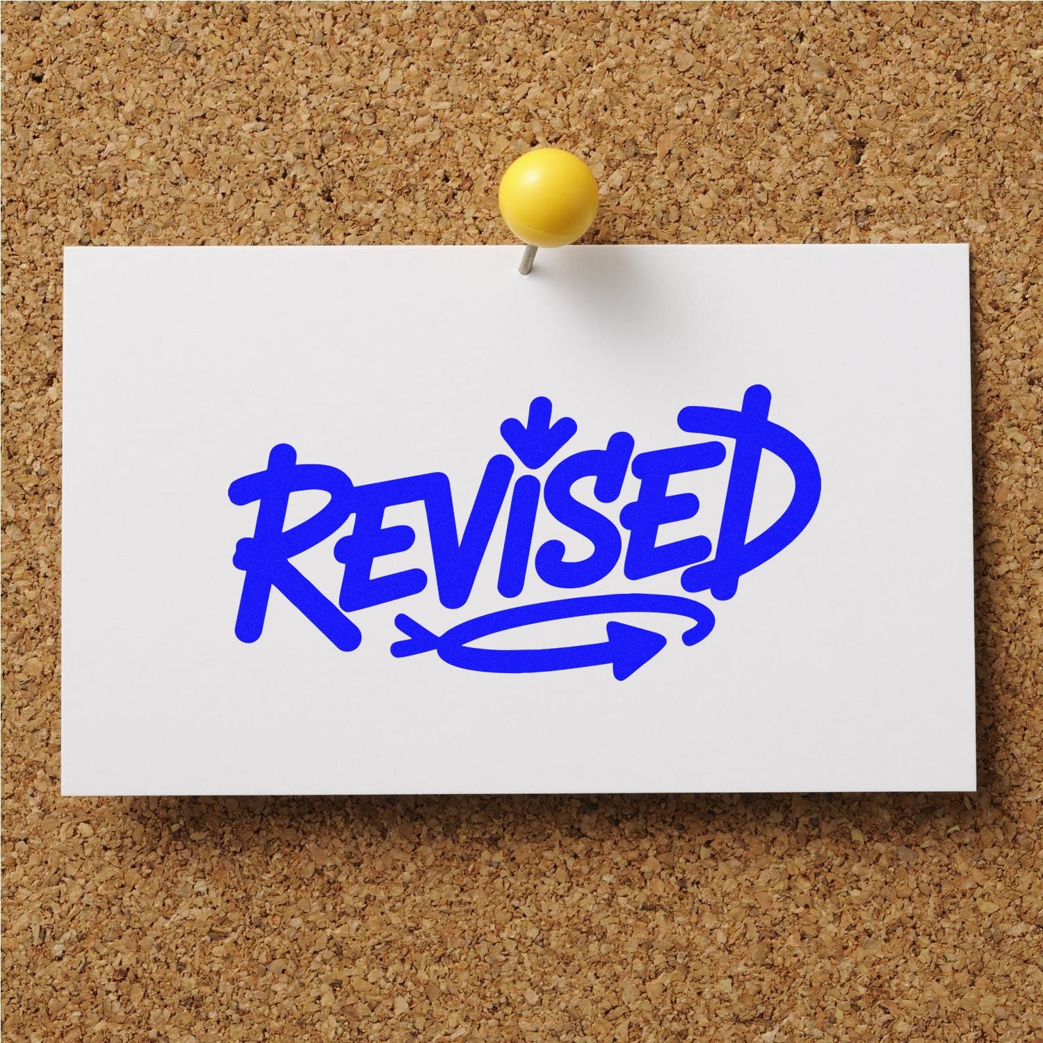 Blue REVISED rubber stamp on pinned white note, ideal for document approval and office review.