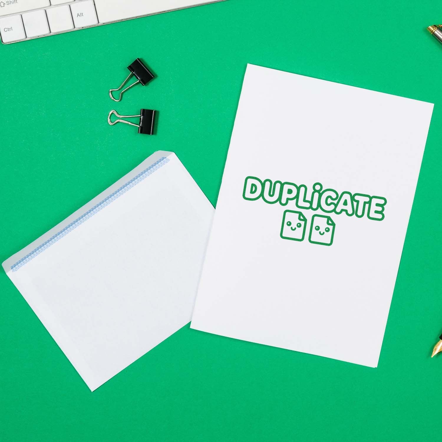 Duplicate rubber stamp impression on office paperwork and envelope for document control and filing.