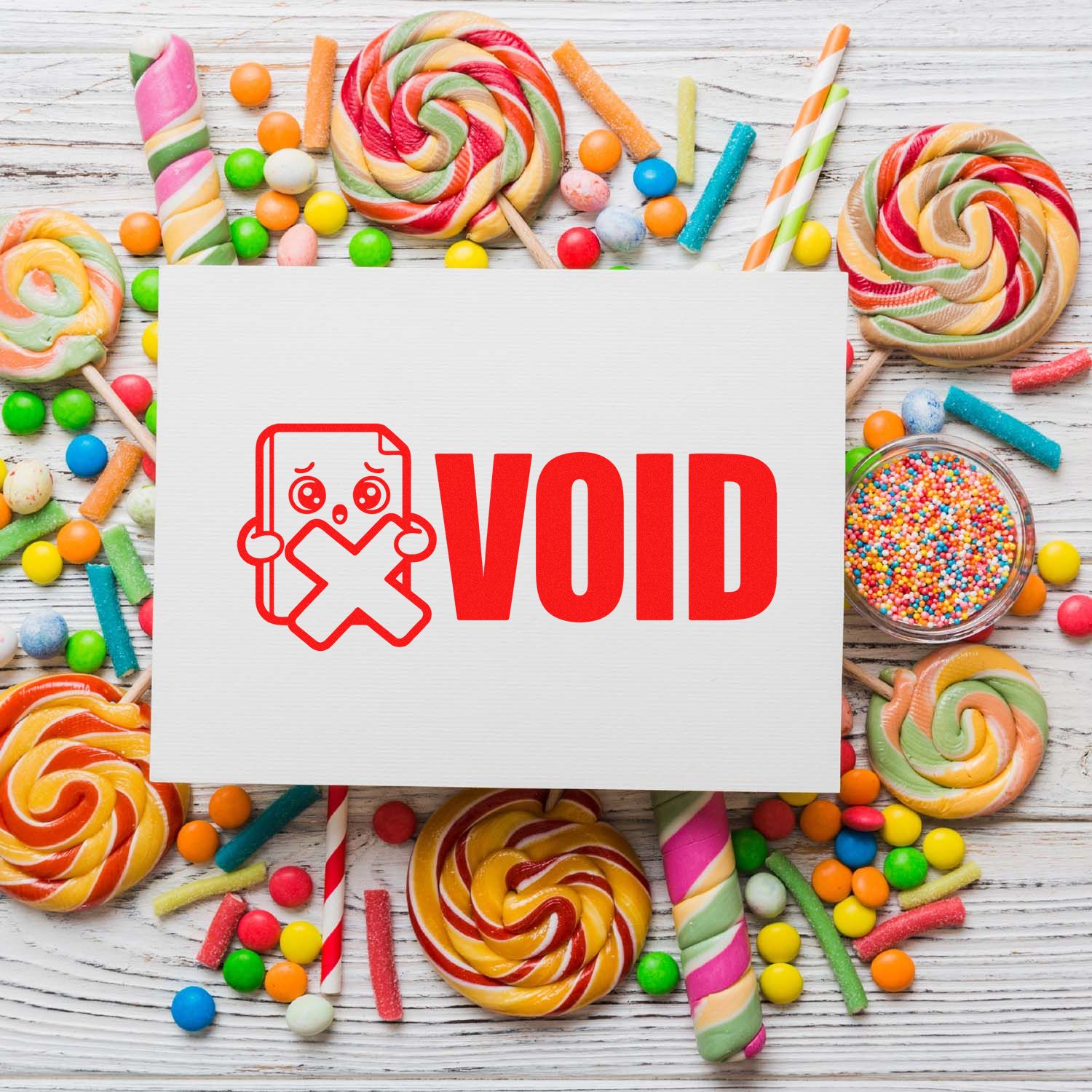 VOID rubber stamp imprint with red canceled document icon on paper, framed by colorful candy on a rustic wood background.