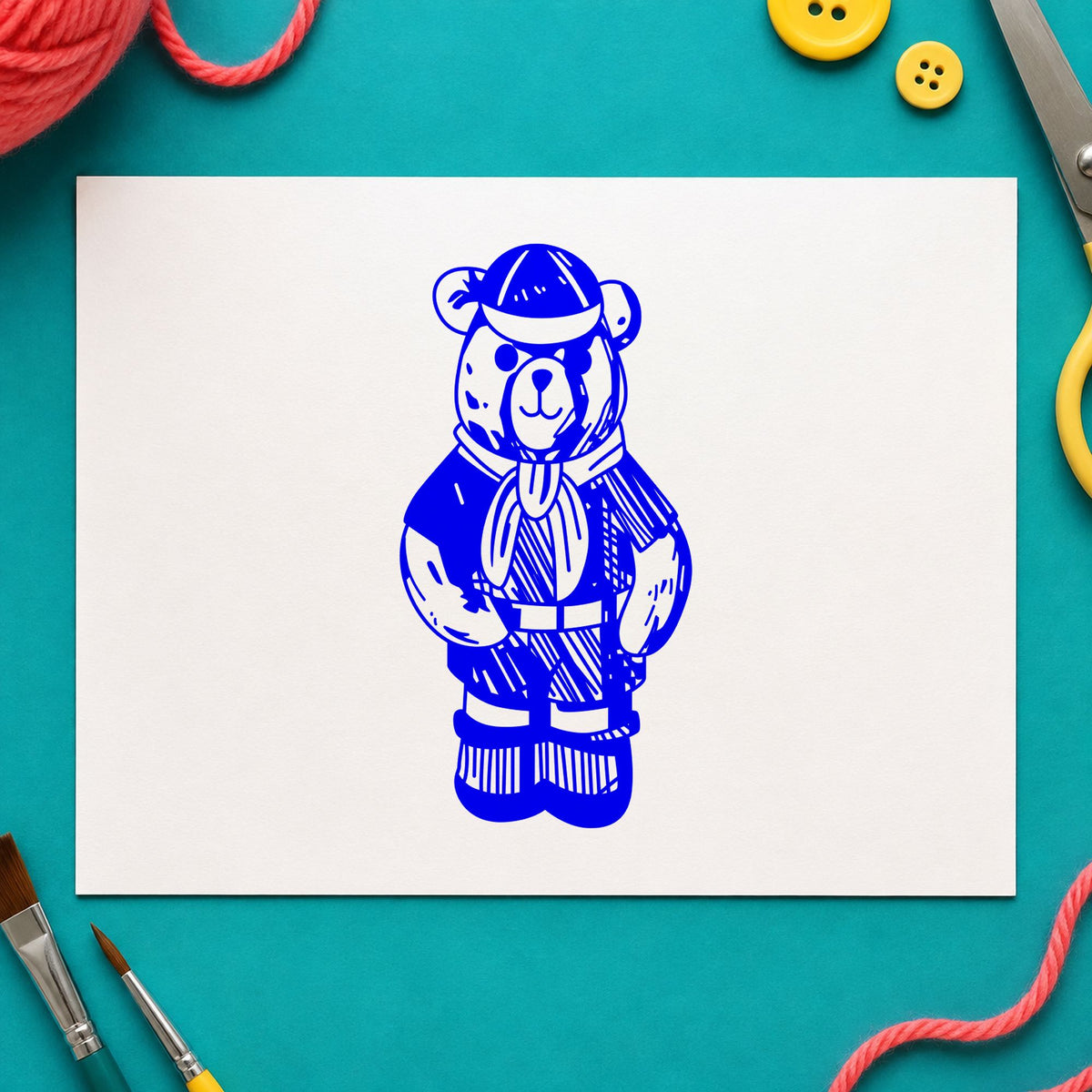 Cub Scout Bear in Uniform Rubber Stamp impression in blue ink on white paper in a styled craft setting.