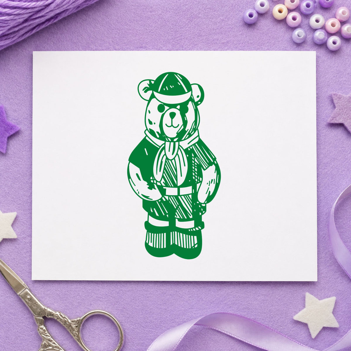 Cub Scout Bear in Uniform Rubber Stamp impression in green ink on white paper in a styled craft setting.
