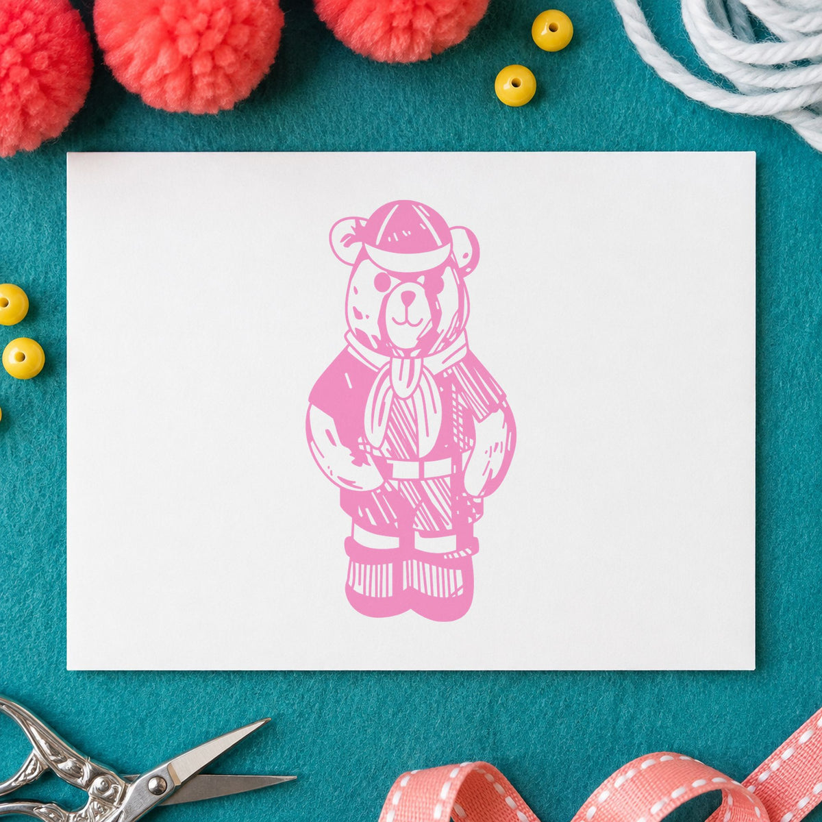 Cub Scout Bear in Uniform Rubber Stamp impression in pink ink on white paper in a styled craft setting.