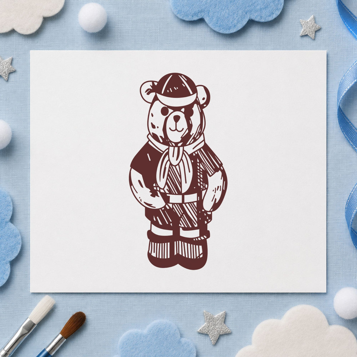 Cub Scout Bear in Uniform Rubber Stamp impression in brown ink on white paper in a styled craft setting.