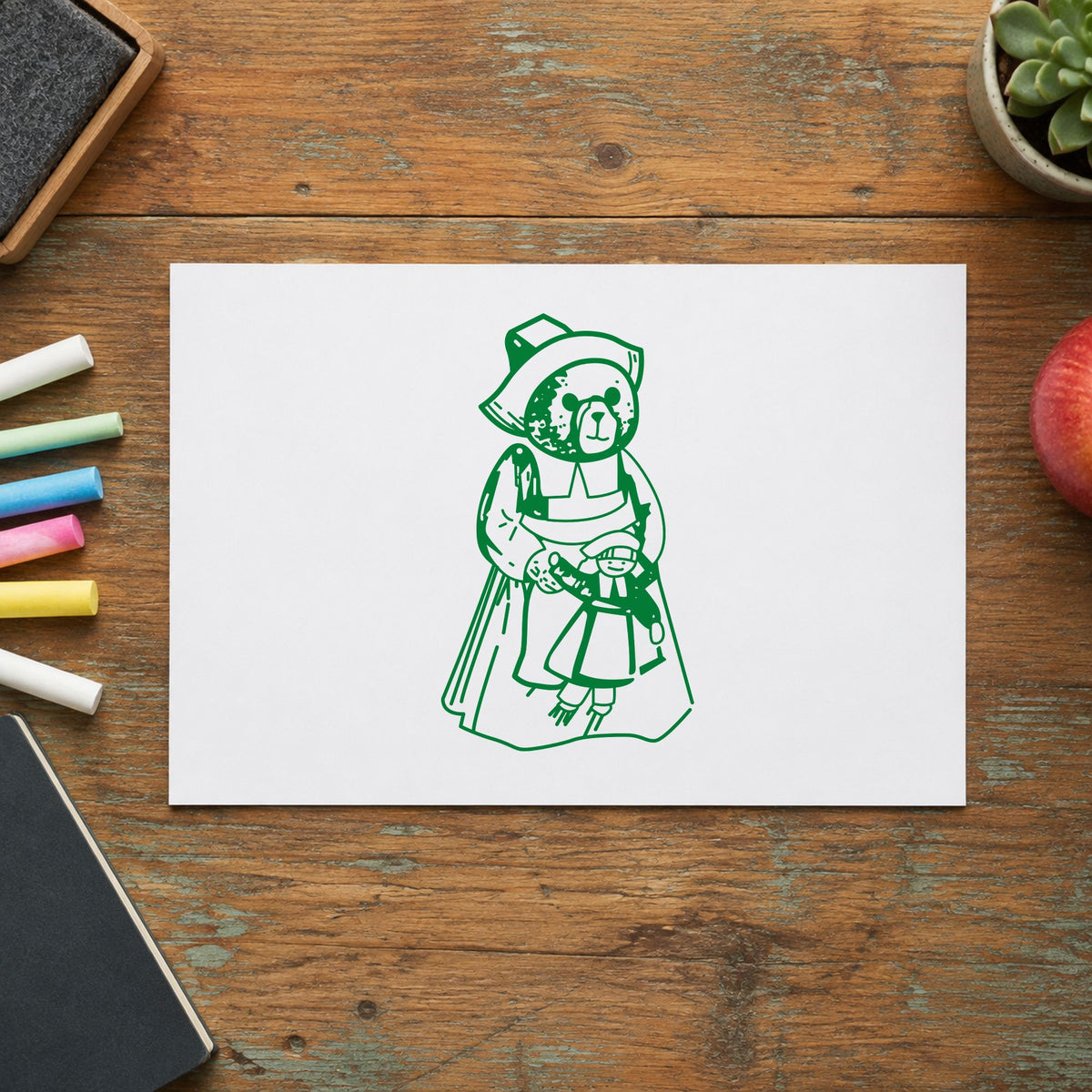 Girl Pilgrim Bear with Doll Rubber Stamp impression in green ink on white paper in a styled craft setting.