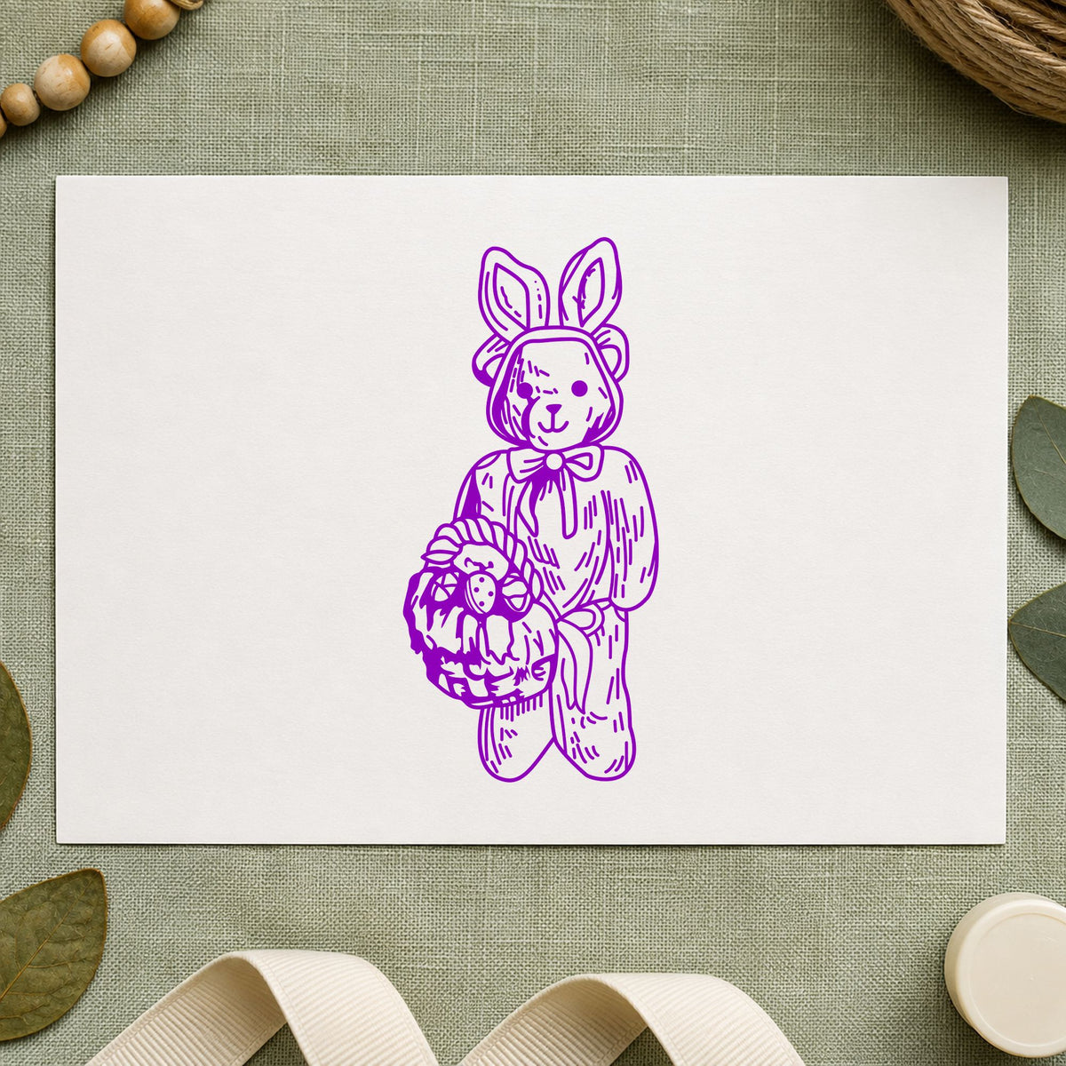 Bear in Bunny Costume with Basket Rubber Stamp impression in purple ink on white paper in a styled craft setting.