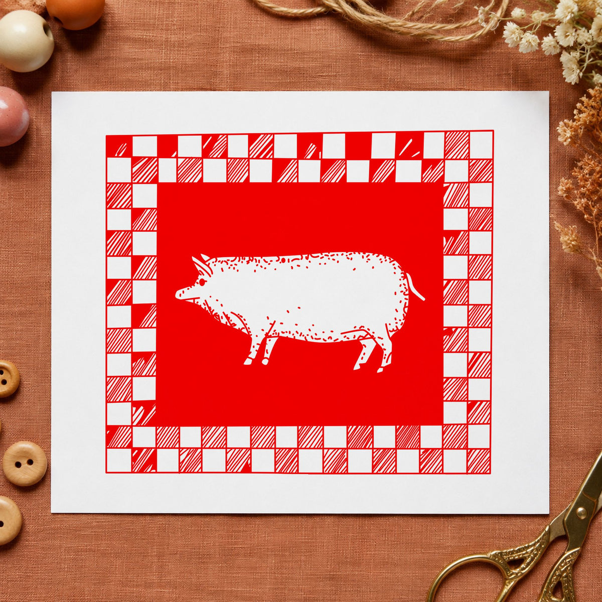 Pig with Checkered Border Rubber Stamp impression in red ink on white paper in a styled craft setting.