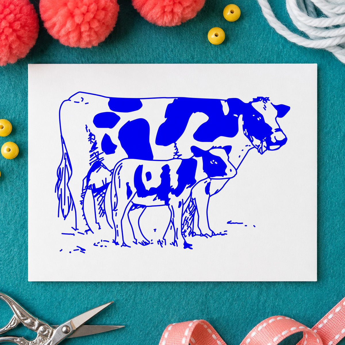 Blue barnyard scrapbook stamp impression featuring the mother cow and calf design on white paper.