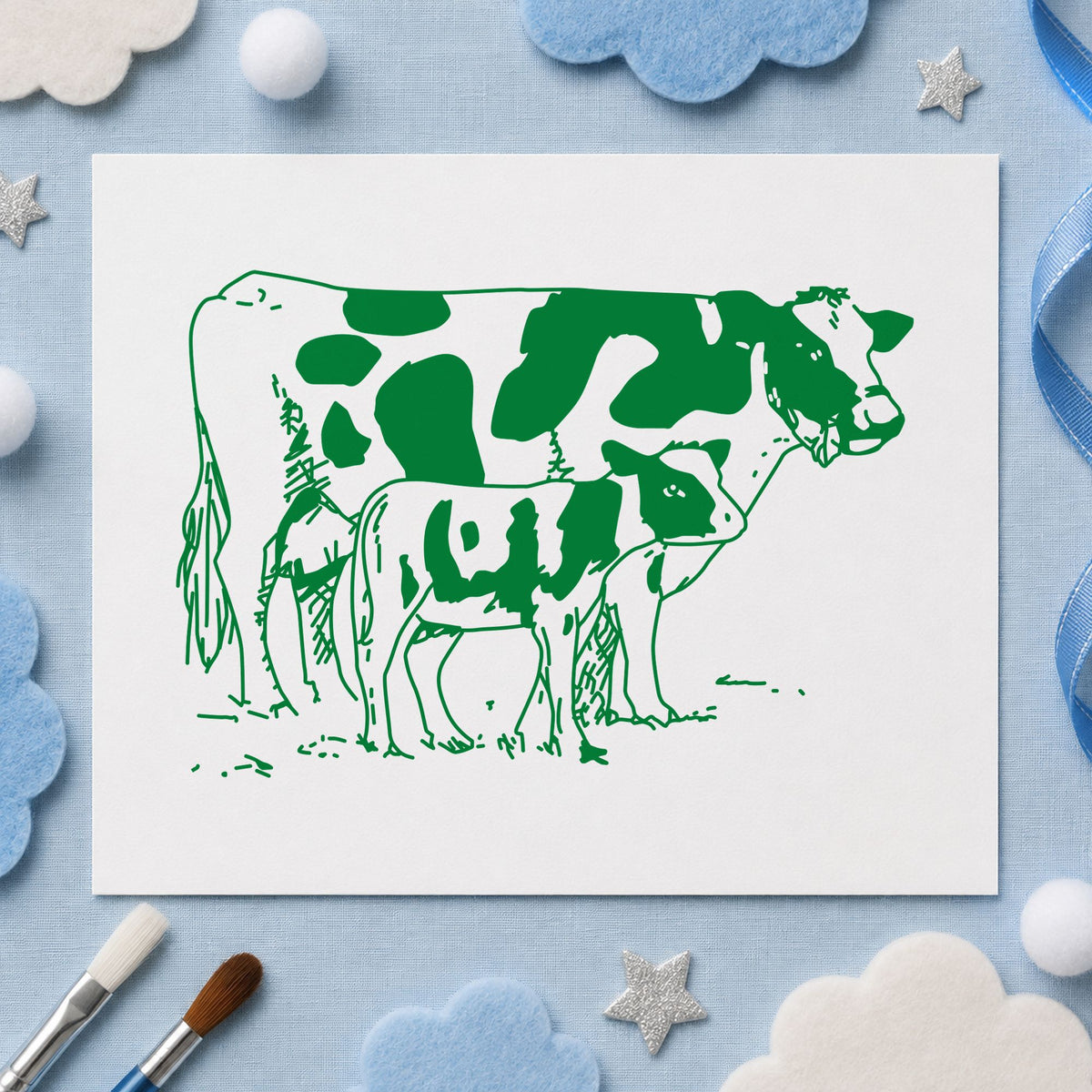 Mother Cow and Calf Rubber Stamp impression in green ink on white paper in a styled craft setting.