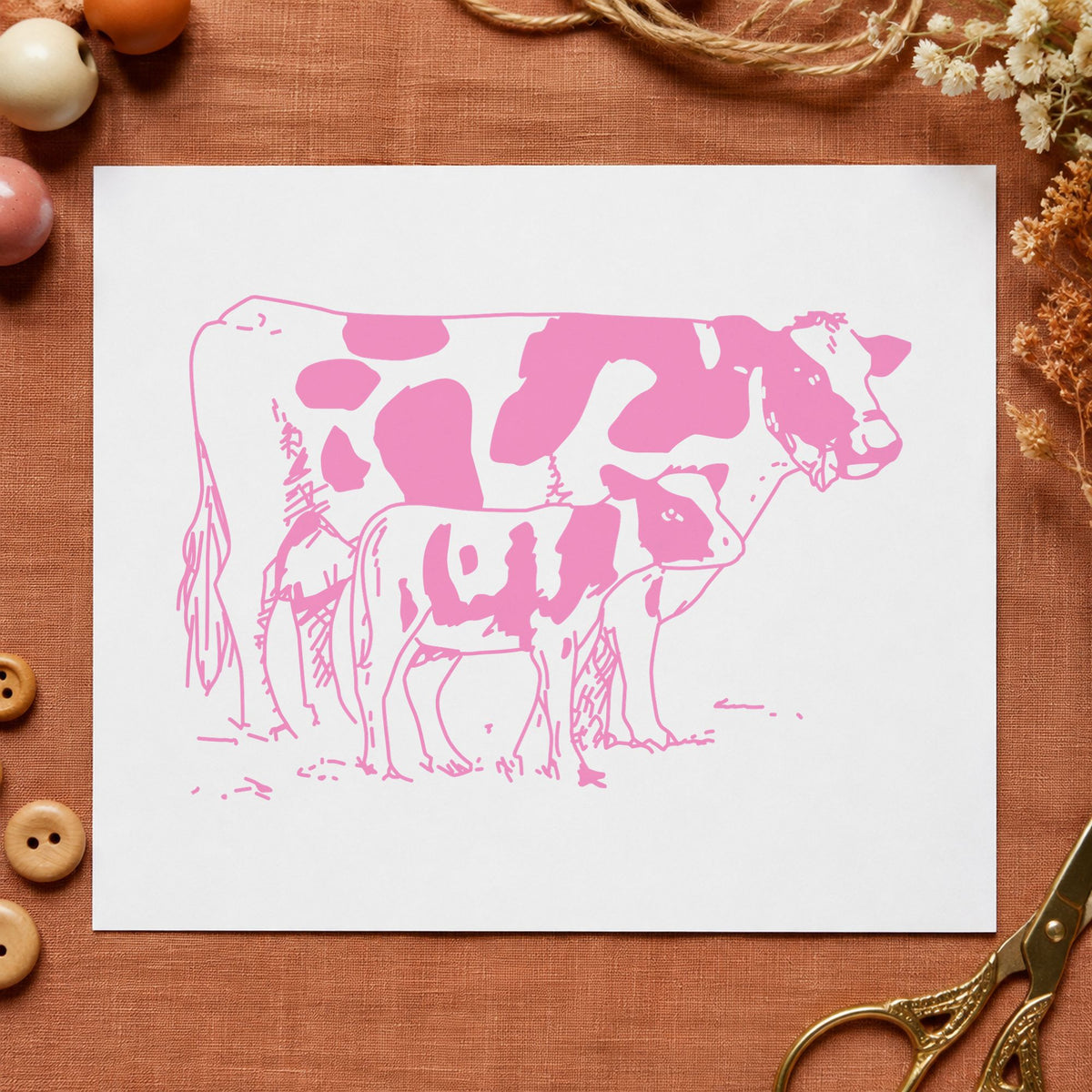 Mother Cow and Calf Rubber Stamp impression in pink ink on white paper in a styled craft setting.
