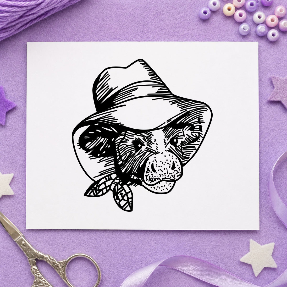 Cow in Cowboy Hat Rubber Stamp impression in black ink on white paper in a styled craft setting.