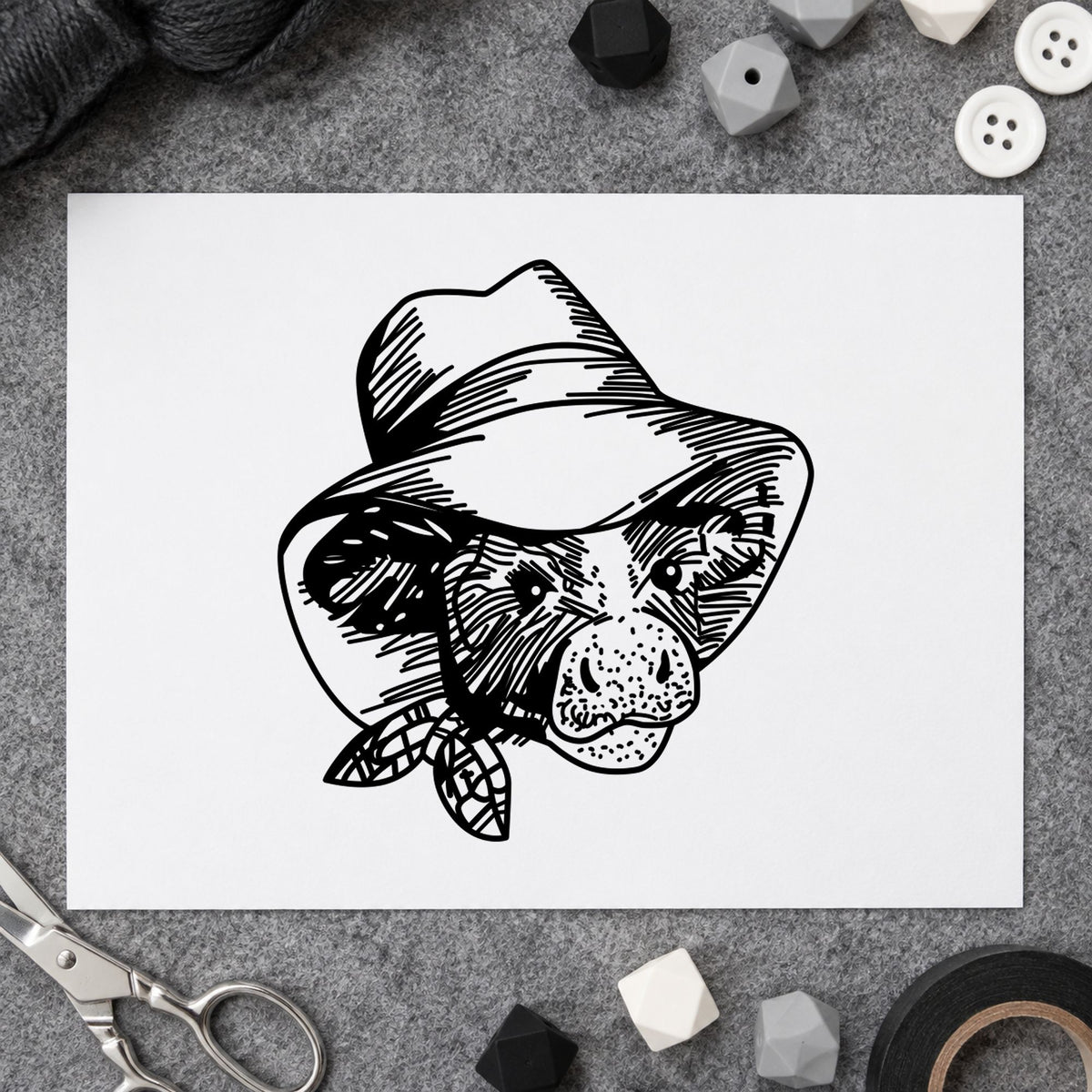 Black impression from a cow rubber stamp, featuring the cow in cowboy hat design on white paper.