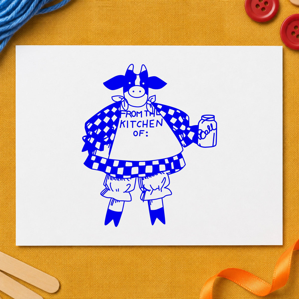 Blue recipe card stamp impression featuring the from the kitchen of cow design on white paper.