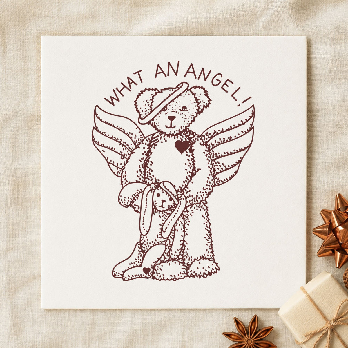 What an Angel Bear and Bunny Rubber Stamp impression in brown ink on white paper in a styled craft setting.