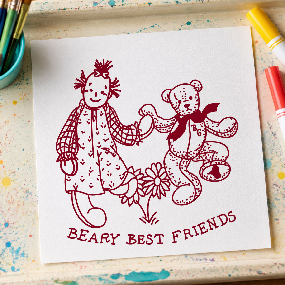 Beary Best Friends Bear and Doll Rubber Stamp impression in burgundy ink on white paper in a styled craft setting.