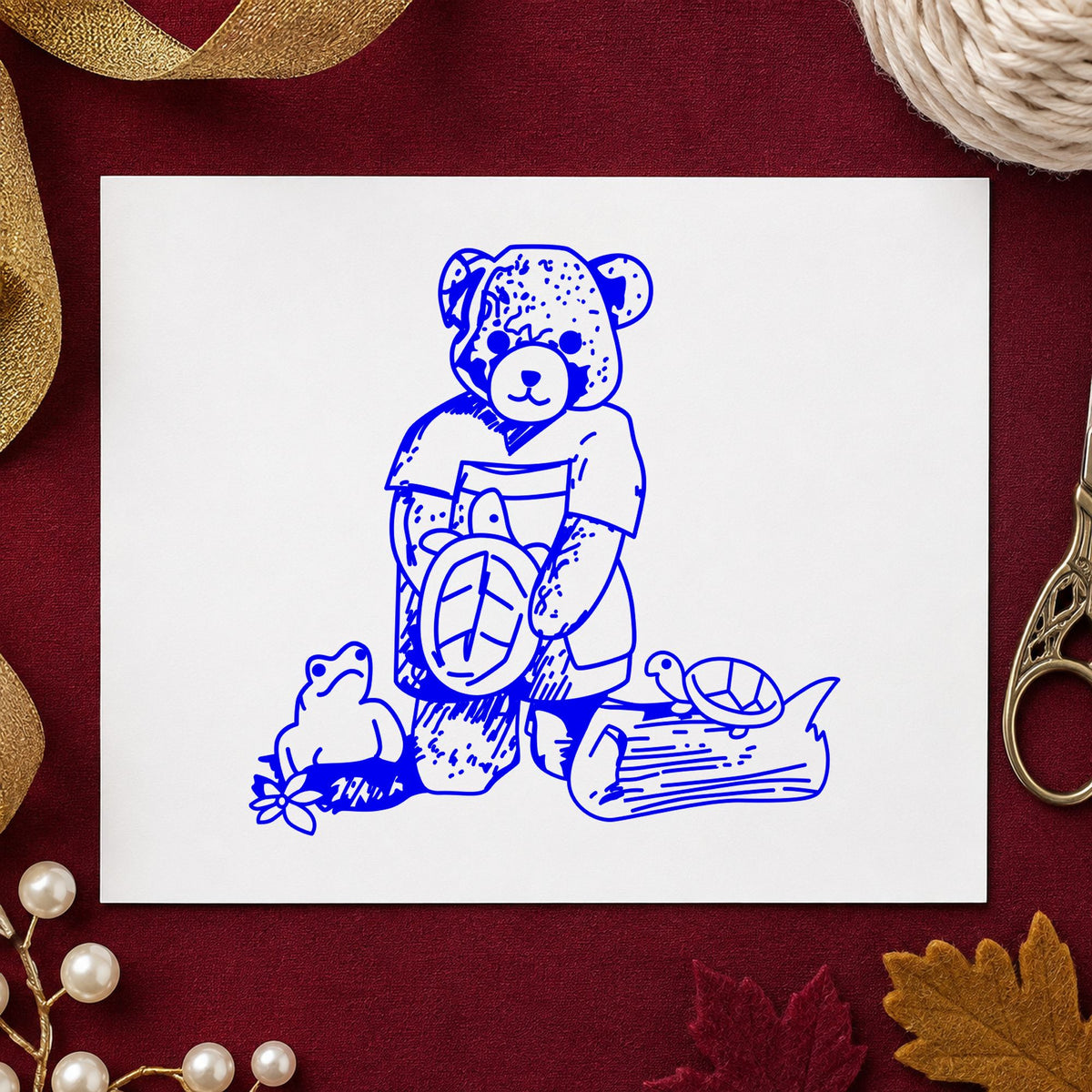 Blue animal scrapbook stamp impression featuring the bear with turtles design on white paper.